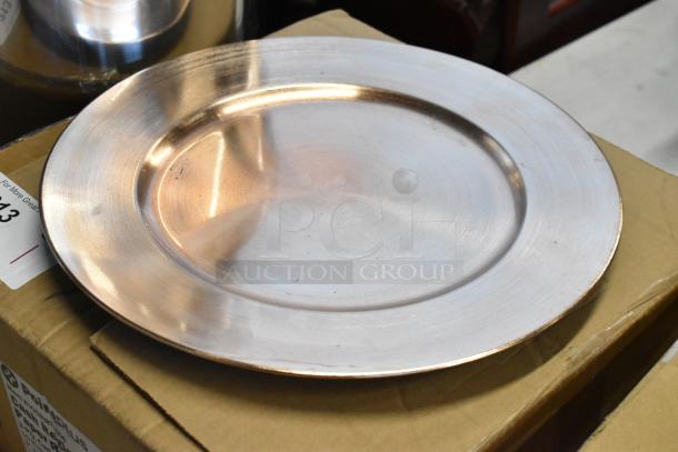 Silver-colored metal plate, lightly scratched surface, resting on a cardboard box. Auction tag partially visible.