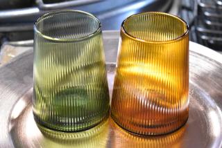 Two ribbed glass tumblers, green and amber, in excellent condition on a metallic tray.