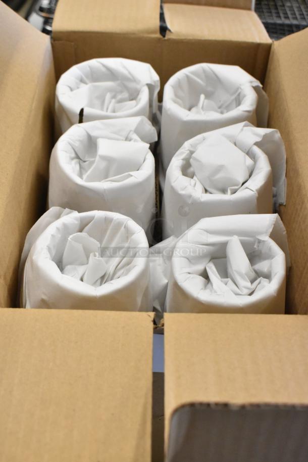 Box containing six cylindrical items wrapped in white paper, indicating careful packaging for protection.