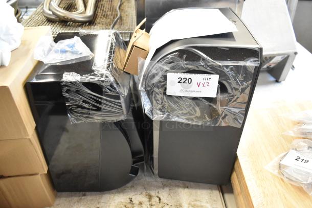 Two sealed black appliances with sticker "220 QTY x2" indicating auction lot number. Items wrapped in plastic.