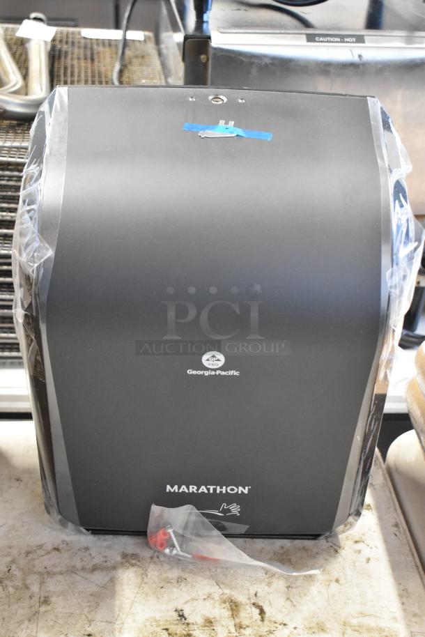 Georgia-Pacific Marathon paper towel dispenser, new condition, black, with instruction and hardware bag, ready for installation.