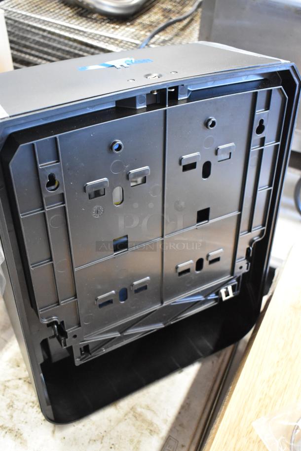 Black plastic electronic device housing, open back panel with multiple mounting slots, slight wear visible.