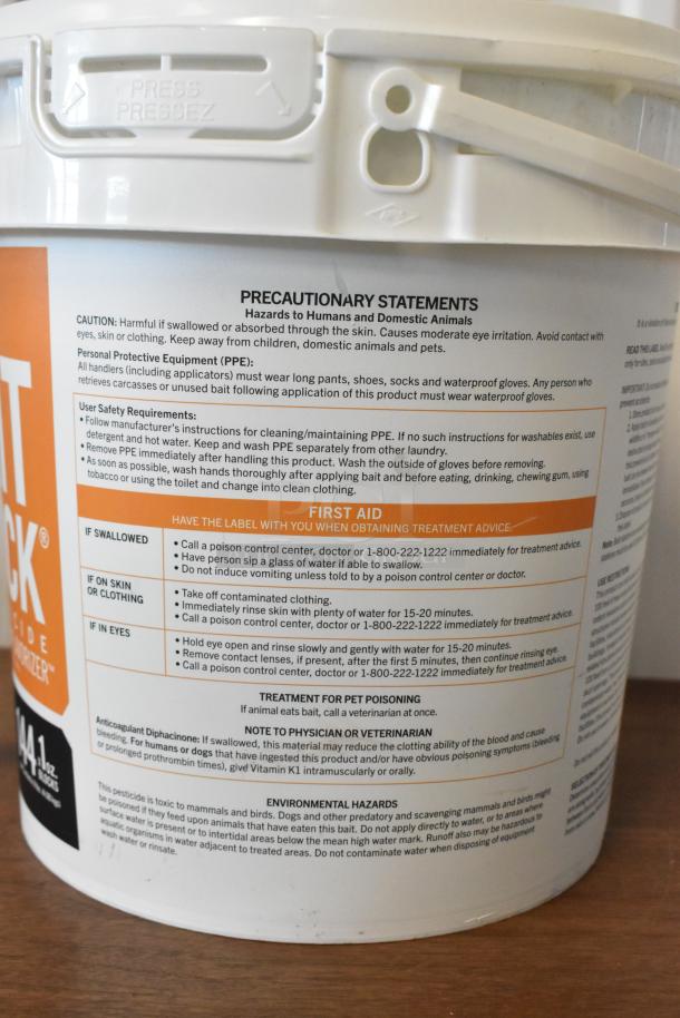 Bucket of pesticide with precautionary and safety statements, PPE requirements, and first aid instructions on the label.