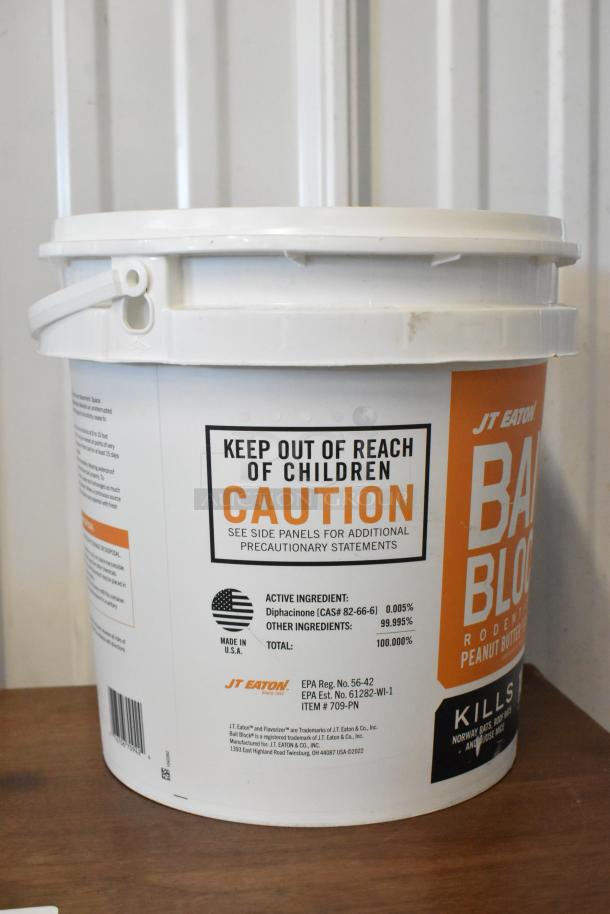 JT Eaton bait block rodenticide in a white bucket, caution label, active ingredient diphacinone, made in USA.