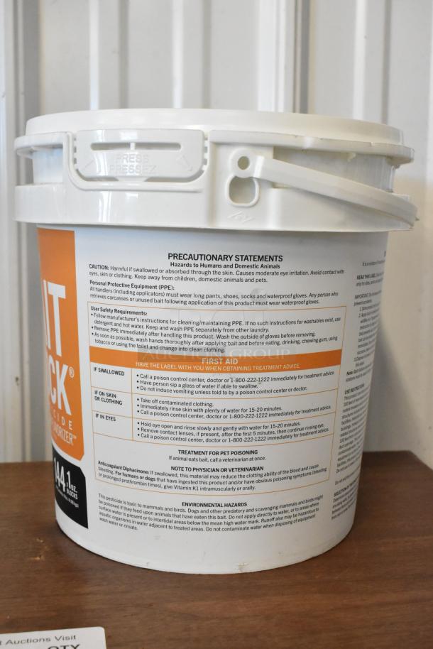 White plastic bucket of rodenticide, labeled "FASTRAC BLOX" with safety warnings and first aid instructions, 4 lb capacity.
