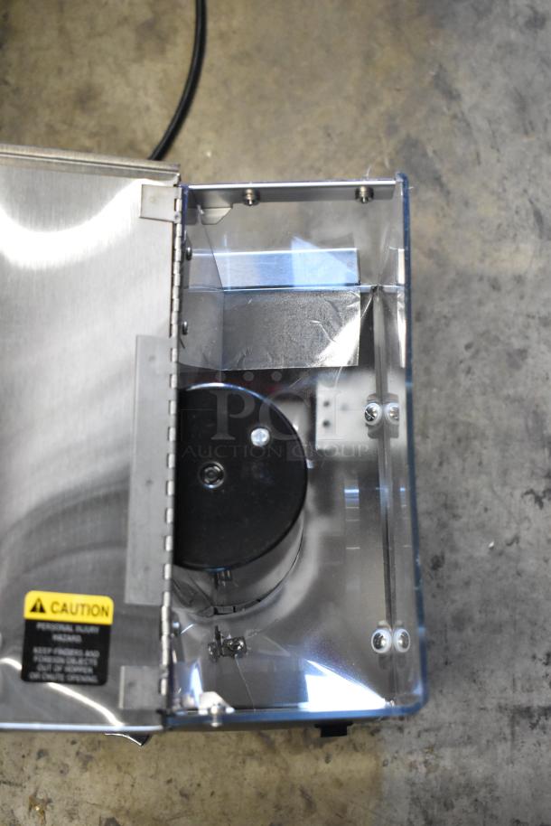 Stainless steel industrial device with a hinged lid, internal wiring, and a "Caution" label warning against personal injury.