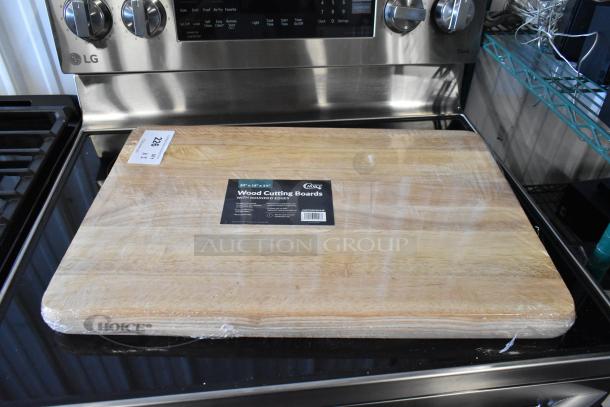 Wood cutting board, 24"x16"x1.5", rounded edges, wrapped in plastic. "Choice" brand label visible. New condition.