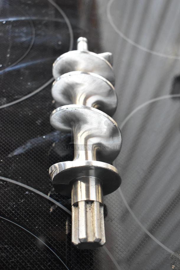 Metal auger screw, slightly worn, with shiny finish and central shaft. Ideal for industrial use.