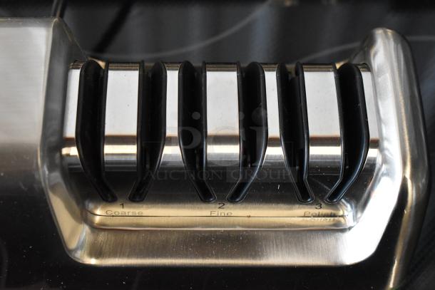 Electric knife sharpener with three slots labeled "Coarse," "Fine," "Polish." Stainless steel, used condition.