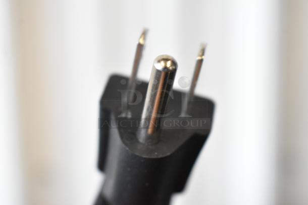 Close-up of a black electrical plug with three metal prongs, in good condition.