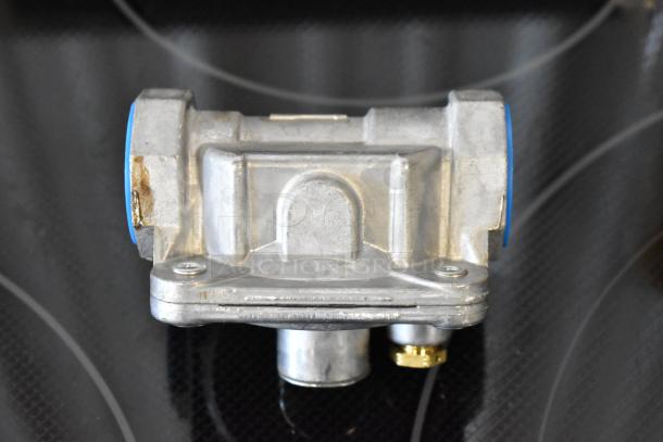 Metal valve assembly with blue-coated ends and surface wear, featuring a brass connector underneath.