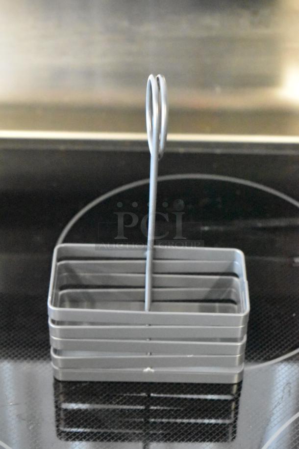 Gray metal napkin holder with a vertical loop handle, modern design, excellent condition.