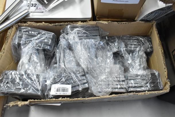 Box of sealed metal machine vises with barcode label "CAD-42-MG." New condition, packed in plastic wrap.
