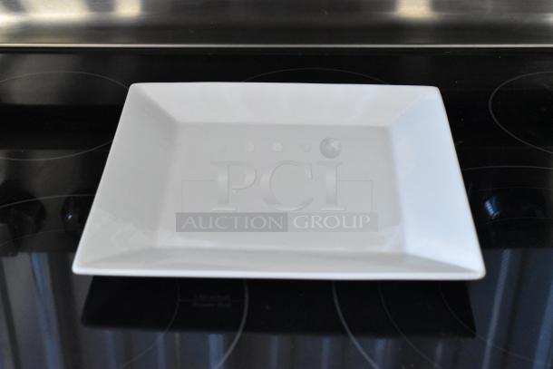 Square white ceramic plate, gently angled sides, pristine condition, glossy finish, ideal for serving or display.