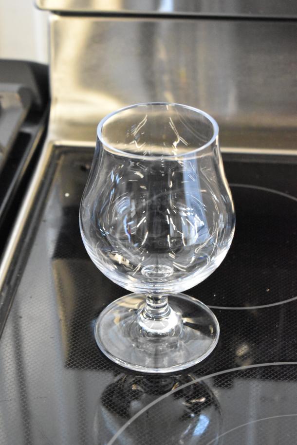 Crystal brandy snifter with elegant curvature, clear glass, pristine condition, approximately 6 inches tall.
