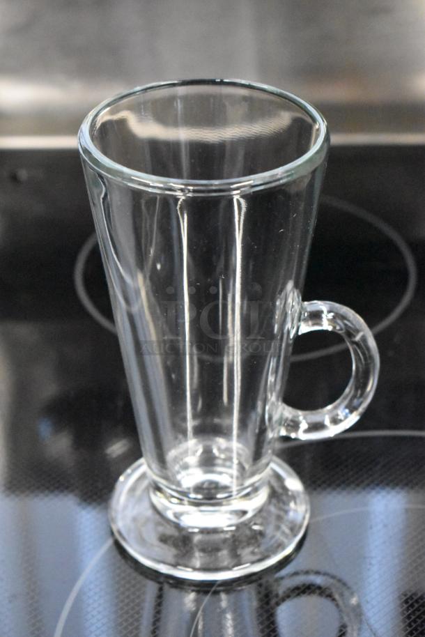 Tall clear glass mug with handle, ideal for hot beverages. Excellent condition, smooth finish, sturdy base.