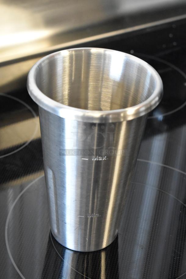 Stainless steel cup with max and min markings, on an electric stove. Ideal for precise measurements. Excellent condition.