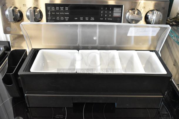 Black condiment organizer with five white removable trays and a clear plastic lid, in excellent condition.