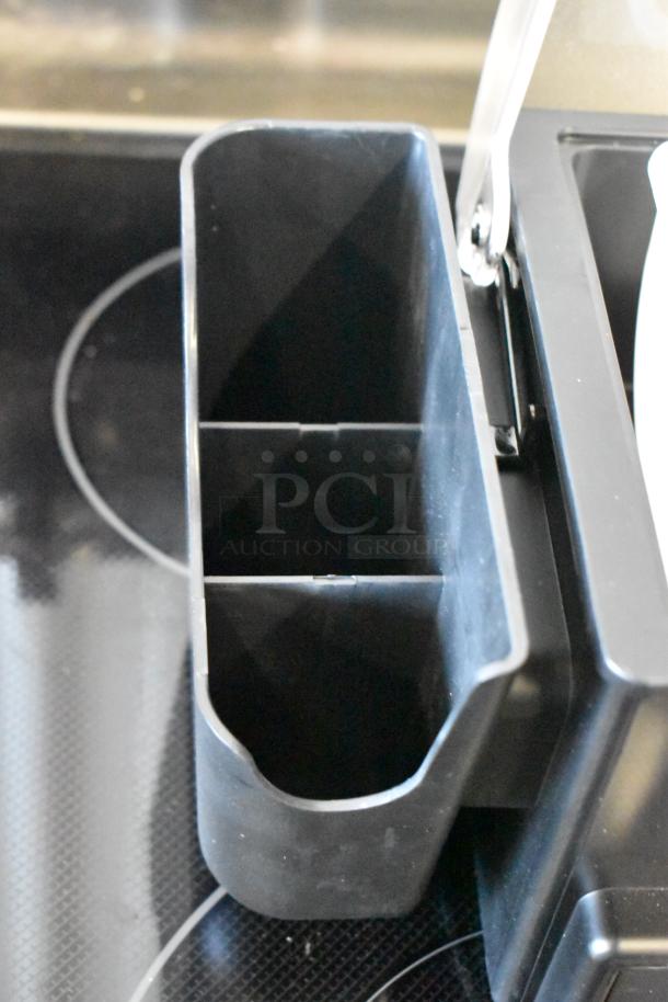 Black plastic organizer with multiple compartments, possibly for kitchen storage. Good condition. No visible markings.