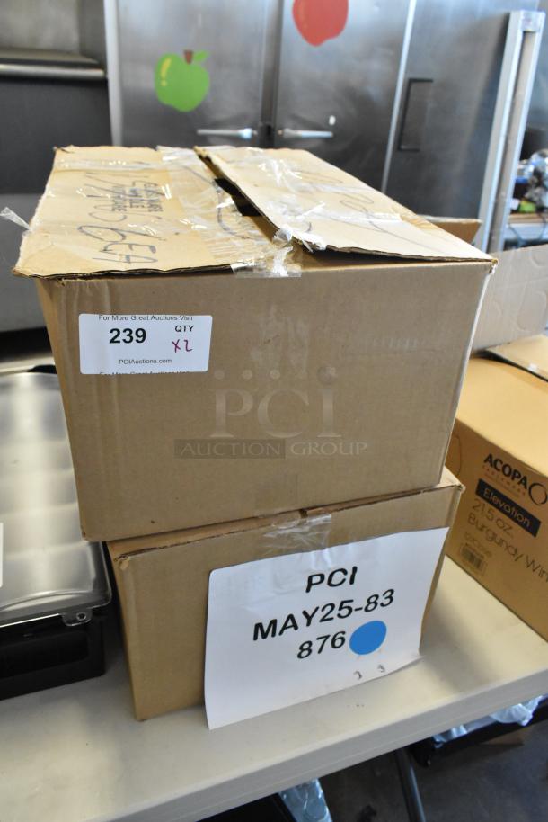 Two cardboard boxes with visible labels. Top box labeled "239 QTY x2," lower box with "PCI MAY25-83 876." Boxes show signs of wear.