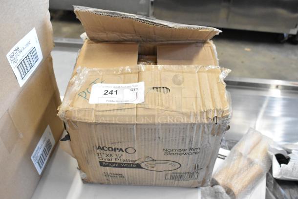 Open box of Acopa 11"x8.5" oval platters, bright white stoneware, narrow rim, 12 per case, visible wear on packaging. Tag: Lot 241.