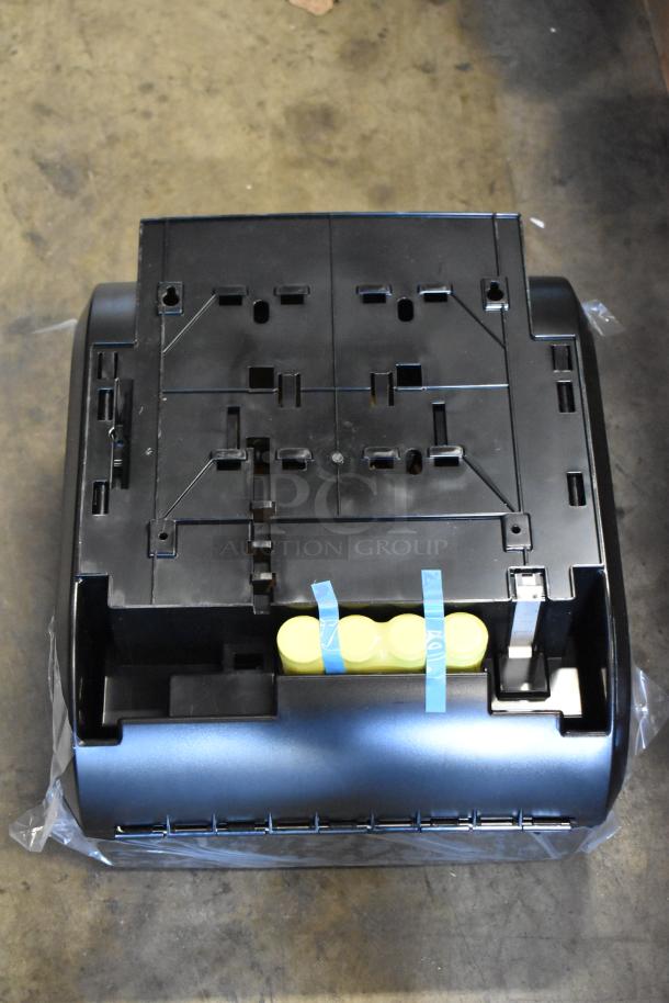 Black electronic device base with modular slots, housing space, and yellow cylindrical parts secured with blue tape. Mint condition.