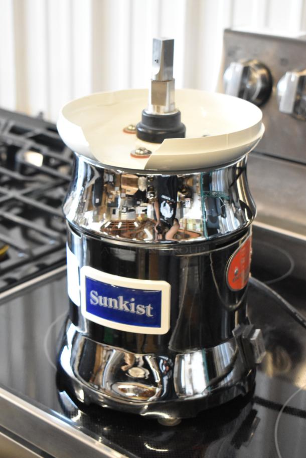 Sunkist commercial juicer with stainless steel body, chrome finish, and visible logo. Used condition with minor wear.