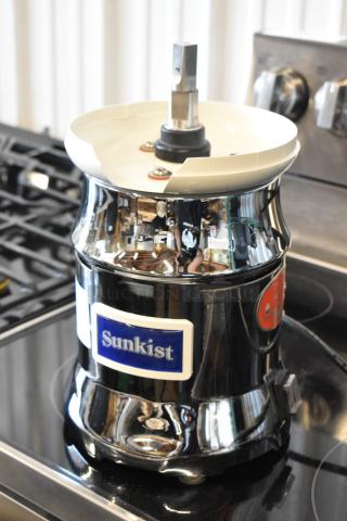 Sunkist commercial juicer with stainless steel body, chrome finish, and visible logo. Used condition with minor wear.