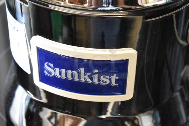 Sunkist juicer with a glossy black finish, blue logo, and white trim, in good condition.