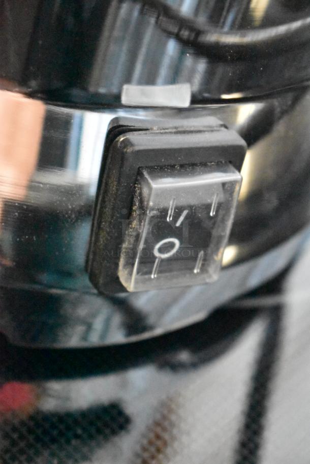 Close-up of a black rocker switch on a metal appliance, showing on/off symbols. Slight dust visible, indicating light use.