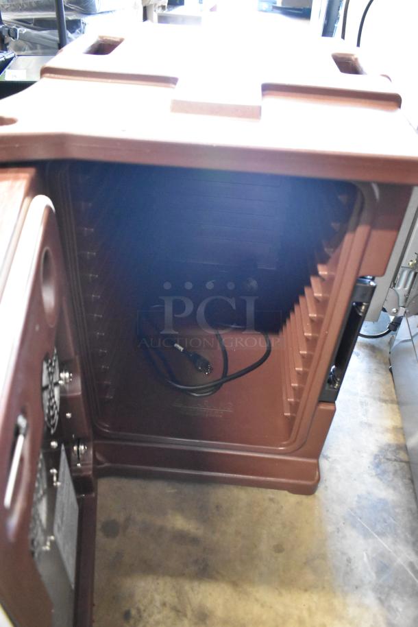 Brown insulated food carrier, open door showing interior shelves and power cord. Durable, commercial-grade condition.