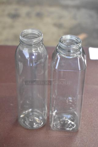Two clear glass bottles, one cylindrical and one square-shaped, in pristine condition. No visible labels.