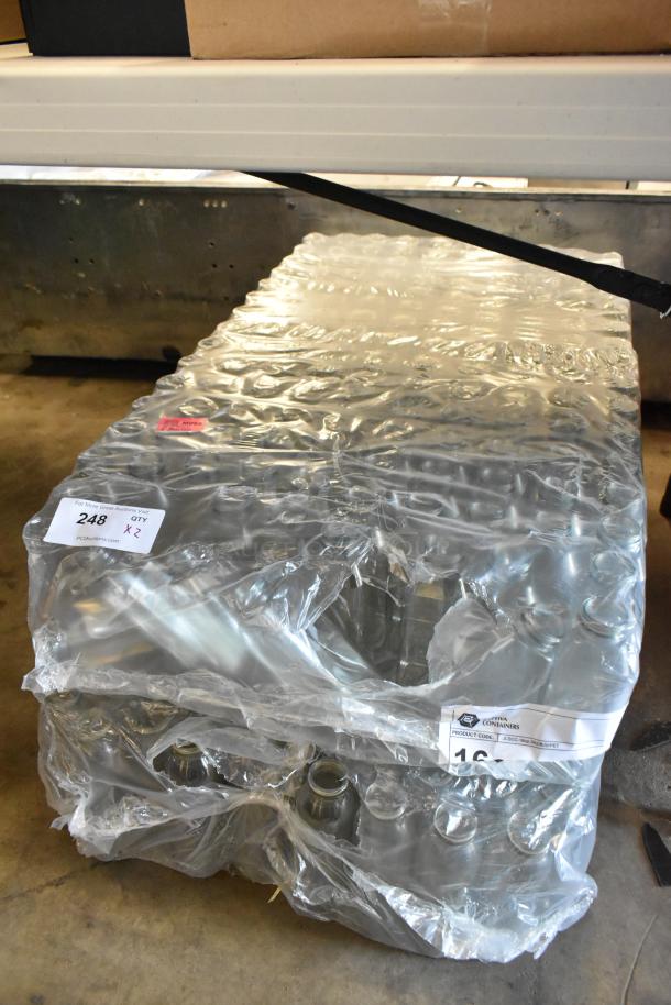Pallet of shrink-wrapped glass bottles, labeled as QTY x2, lot number 248, new condition.