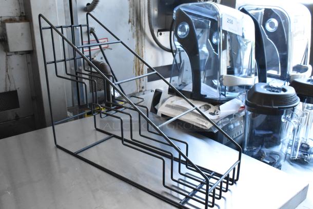 Metal wire display rack, tiered design, suitable for kitchen or commercial use, shown on a stainless steel counter.