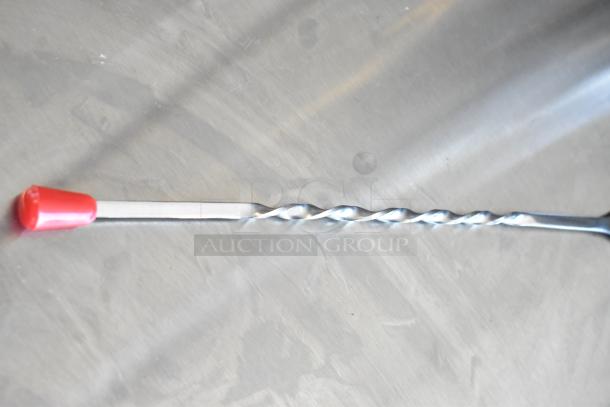 Metal twist drill bit with a red plastic cap, in excellent condition, on a light surface.