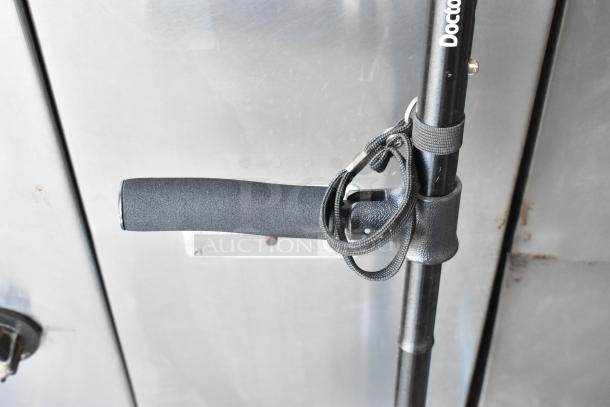 Black telescopic walking stick with grip handle, wrist strap, and visible "Doctor" branding, in excellent condition.