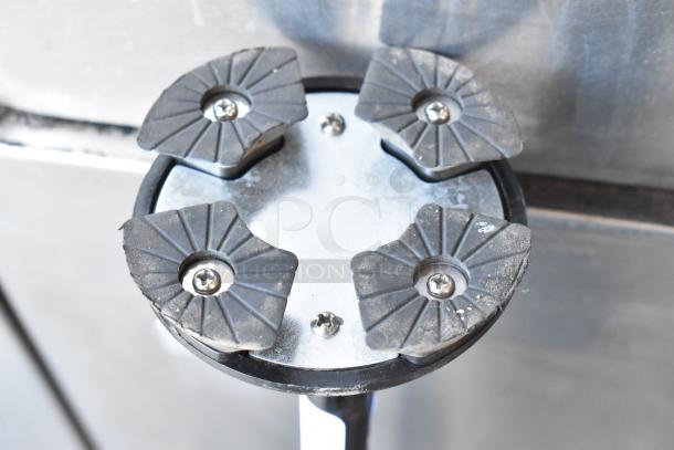 Metallic stool base with four rubber feet, each secured by screws. Shows signs of wear and use.