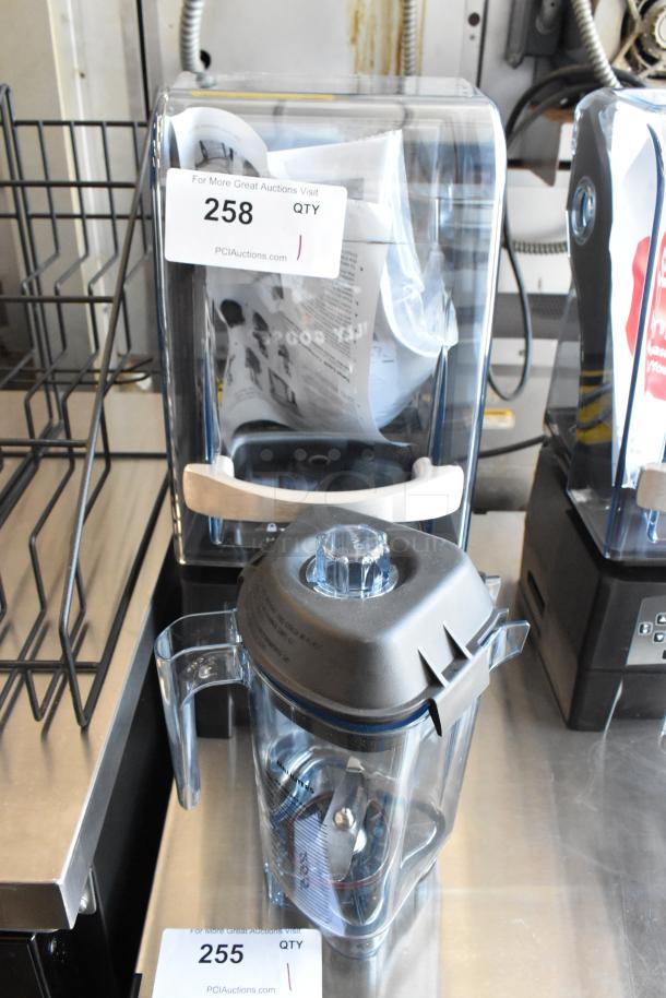 Commercial blender with clear lid and pitcher, metal base, and internal blades. Labels show lot numbers 258 and 255.