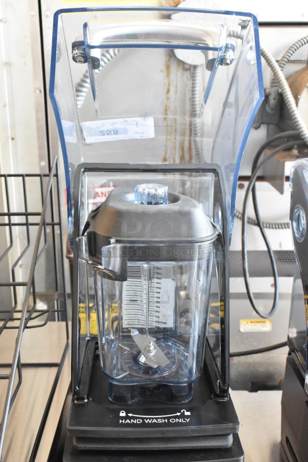 Commercial-grade countertop blender with clear sound enclosure and measurement markings, labeled "Hand Wash Only."