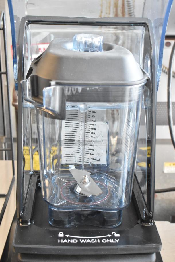Commercial blender with clear Tritan container, capacity markings, and stainless steel blade. "Hand Wash Only" label visible.