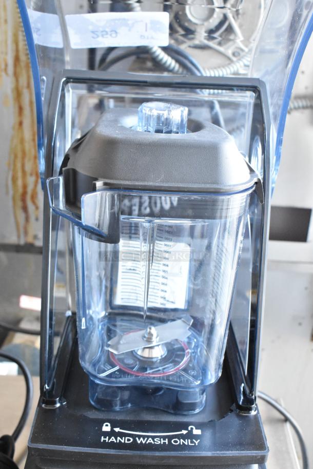 Commercial blender with transparent pitcher and blade assembly, marked "Hand Wash Only," features measurement labels.