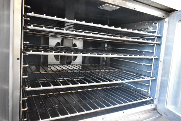 Commercial stainless steel oven with five wire racks, lightly used, clean interior. Ideal for industrial kitchen use.