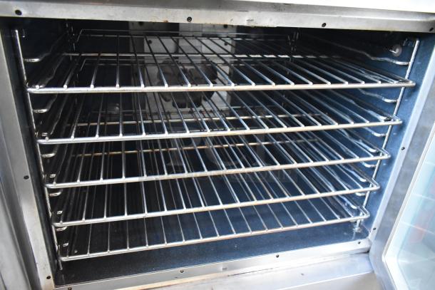 Commercial-grade oven interior with six wire shelves, stainless steel construction, well-maintained, suitable for professional kitchens.