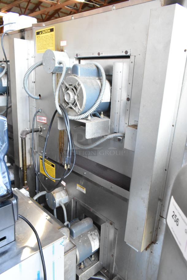 Industrial metal machine with exposed motors and wiring, labeled caution signs, showing visible wear. Suitable for heavy-duty tasks.