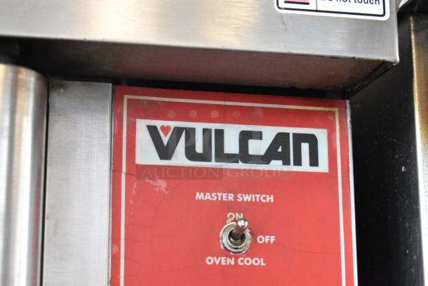 Vulcan oven control panel with master switch for "On," "Off," and "Oven Cool" settings. Silver casing, visible wear.