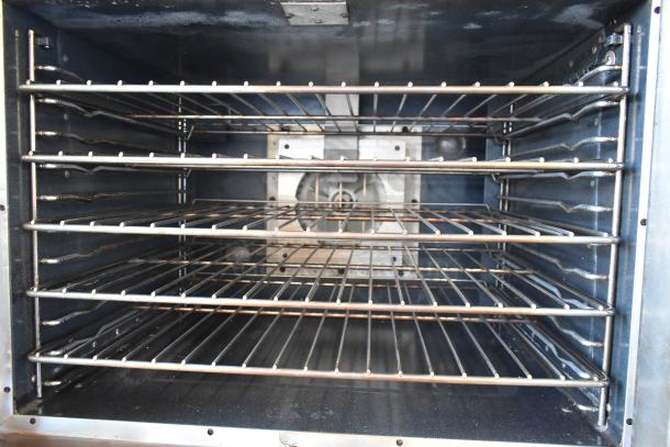 Commercial stainless steel oven interior, featuring four adjustable wire racks in excellent condition.