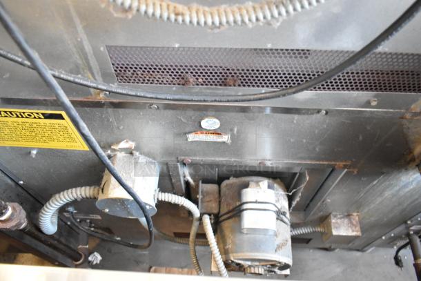Industrial machinery component, metal casing, electrical wiring, and motor. Visible caution and warning labels. Condition shows wear.