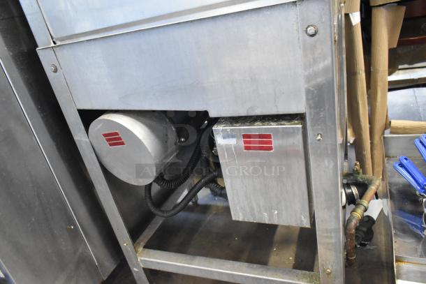 Commercial kitchen equipment with stainless steel housing, featuring electrical components and red-striped labels. Appears in used condition.
