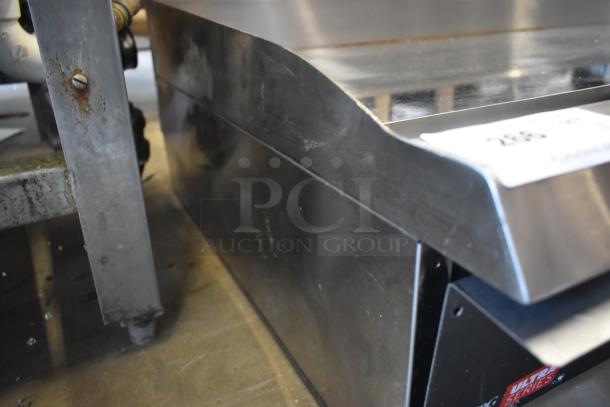 Stainless steel commercial flat-top grill, showing reflective surface and slight wear. Visible label reads "ULTRA SERIES".