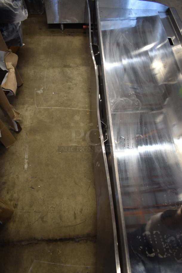 Stainless steel commercial sink, slightly scratched surface, with side bracket. Good condition for industrial use.